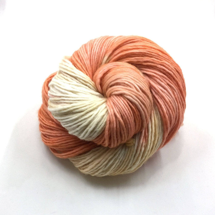 Worsted Weight Merino Wool Yarn donut ball in Cuddly (orange and yellow) on a white background