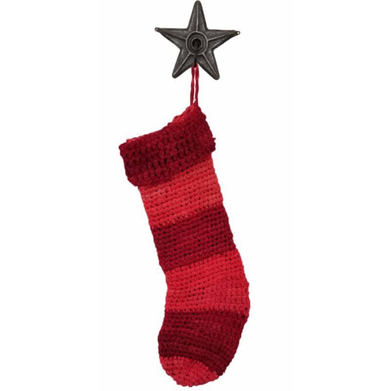 Shaded red stocking hanging on a metal star hook on a white background