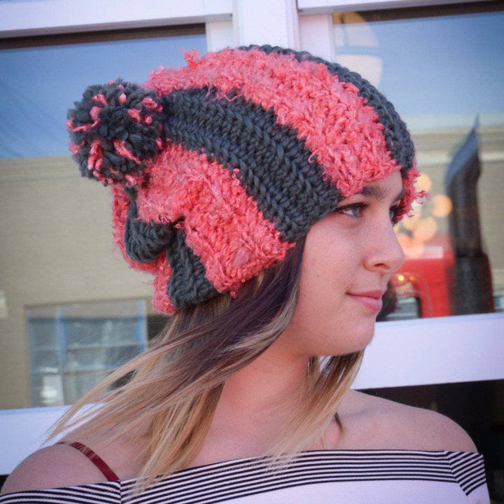 Woman waering the Striped Double PomPom Hat in pink and gray