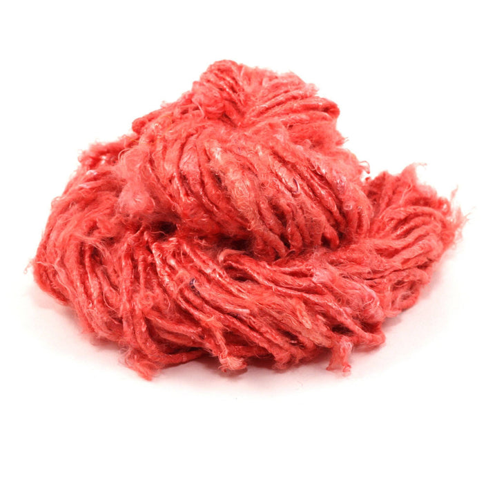 Banana fiber yarn donut ball in Coral on a white background
