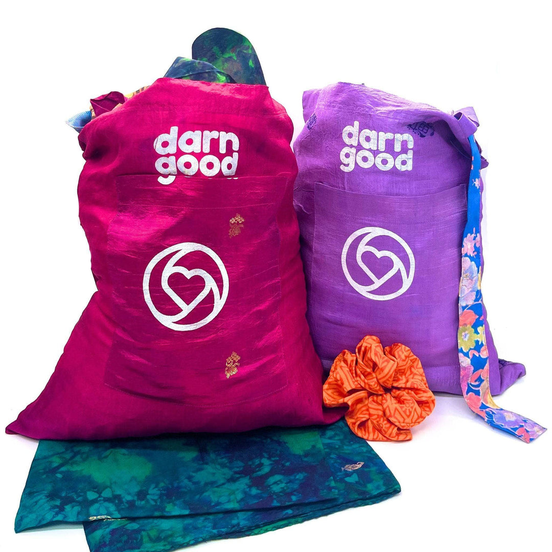 Two Sari Silk Tote bags sitting on a white background. They're filled with accessories made from reclaimed sari.