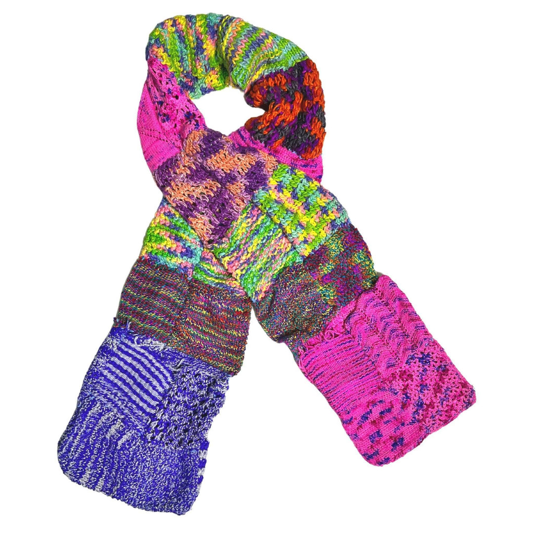 Patchwork scarf (multicolor) with pockets laying on a white background.