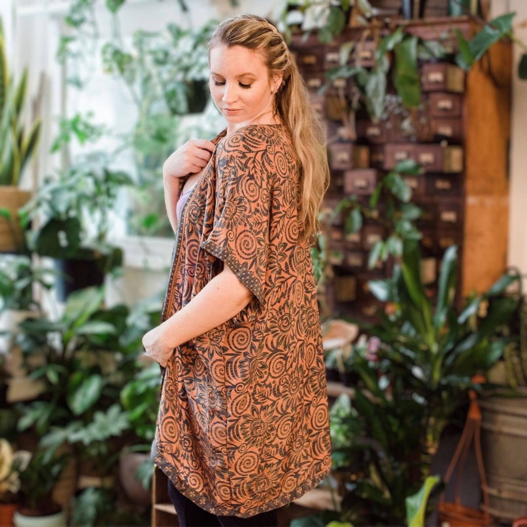 Girl wearing the amara duster standing in front of plants
