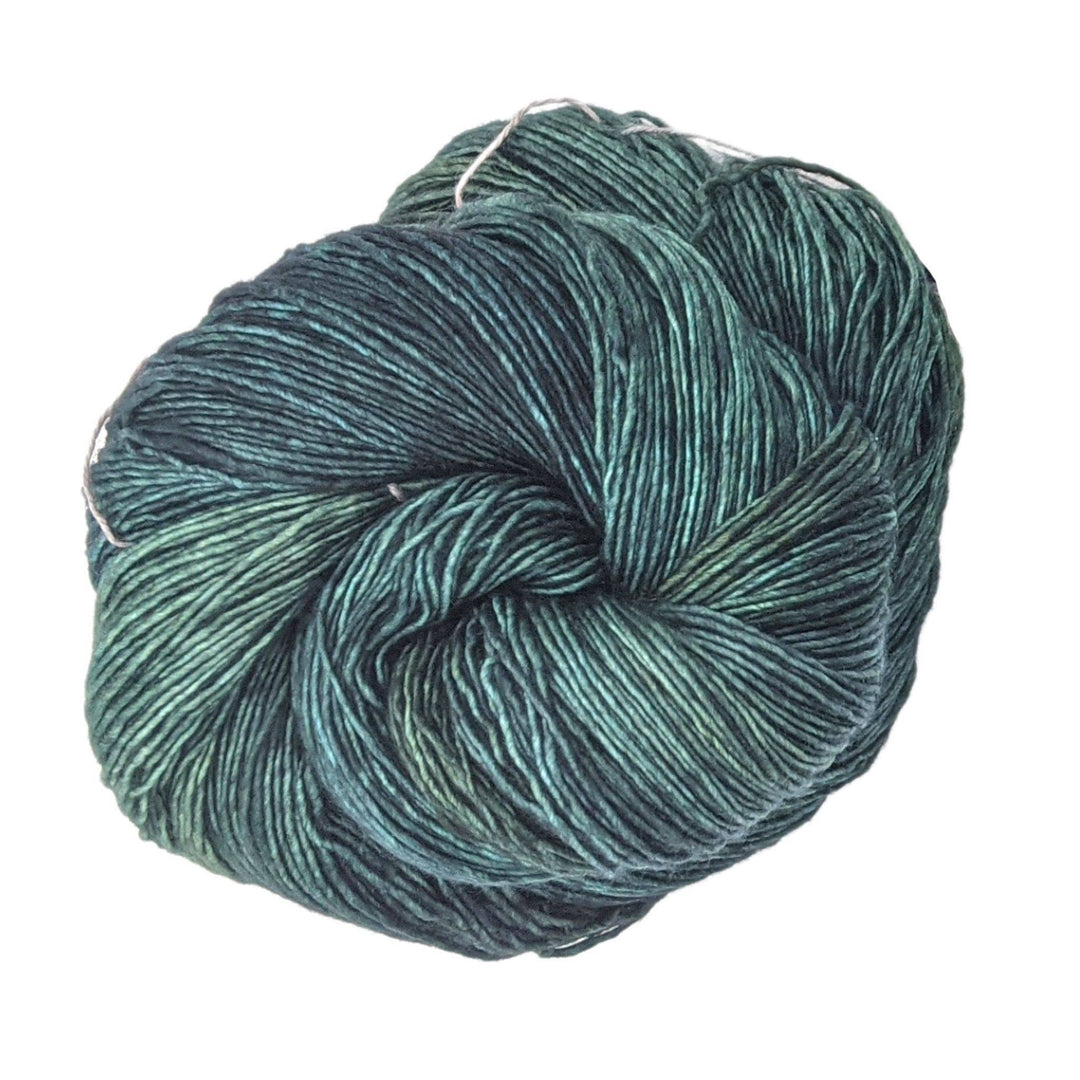 skein of fiona (tonal green) yarn in front of a white background.