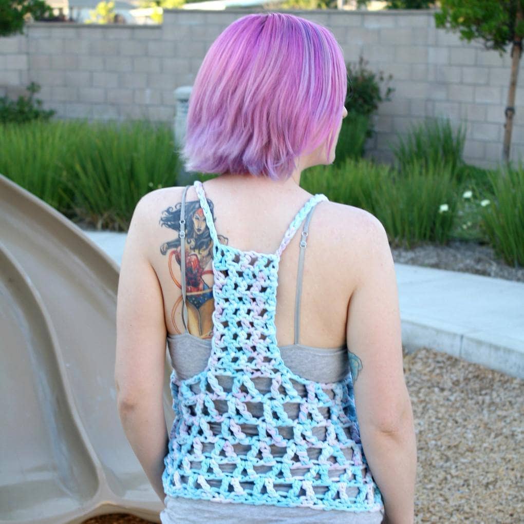 Woman with pink hair wearing The Celia Tank Top in front of a children's playground