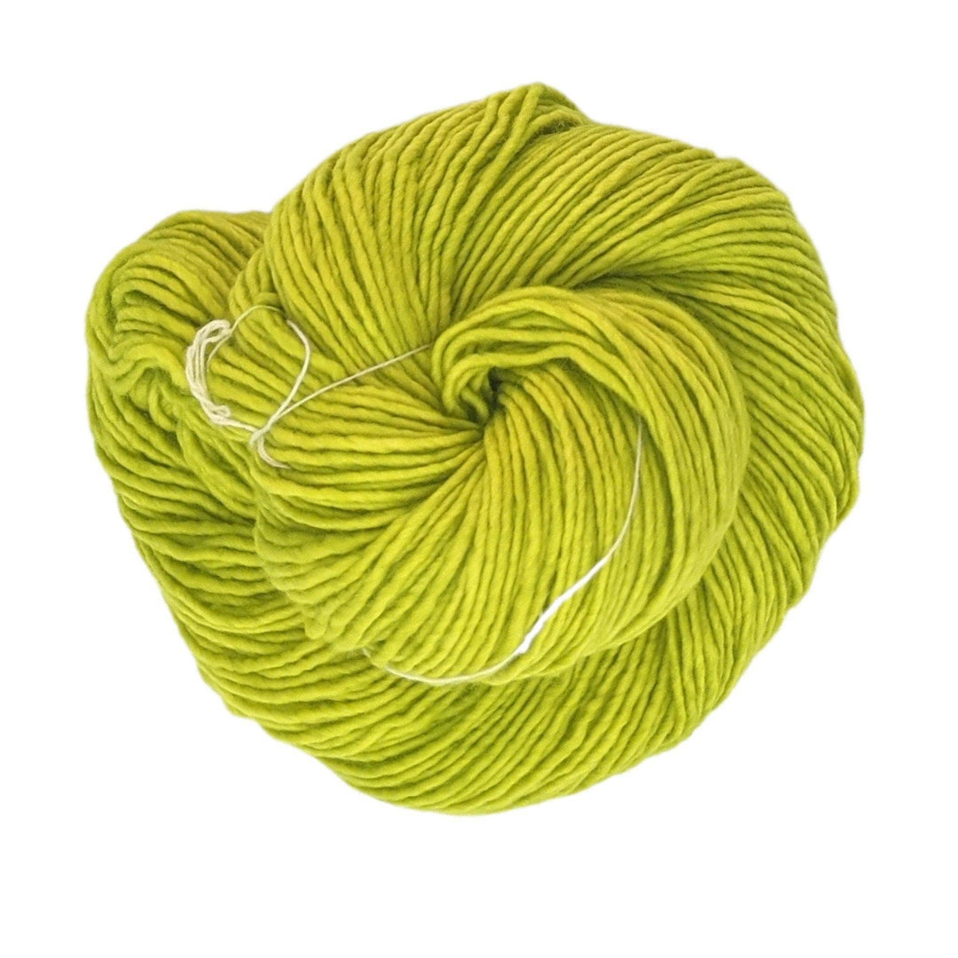skein of single ply apple green malabrigo wool yarn in front of a white background.