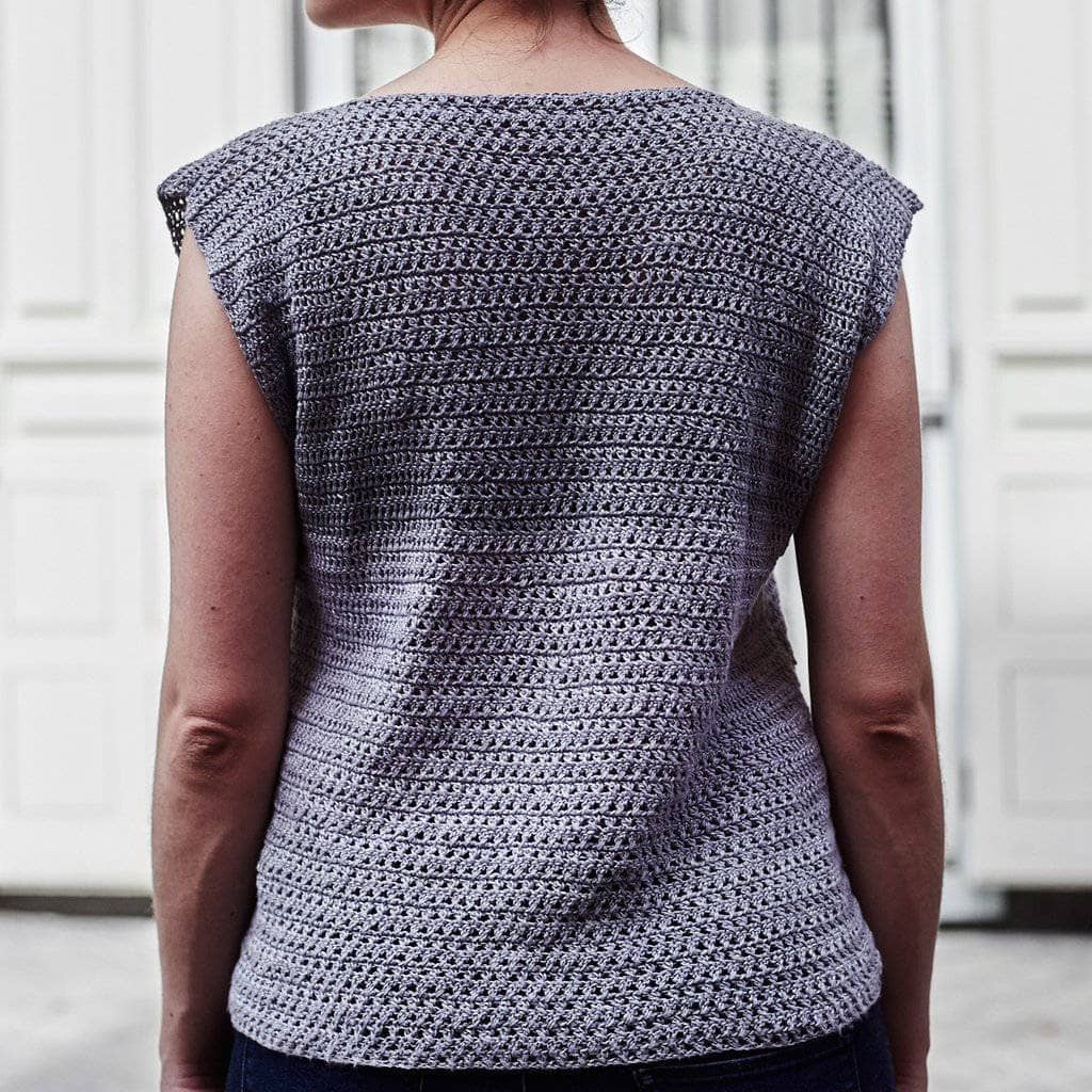 Woman wearing the Crossed Stitched Top in Gray against a white background
