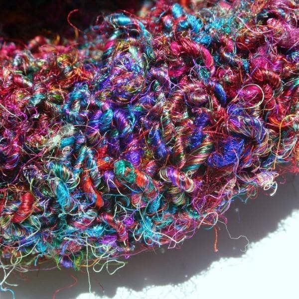 Close up of multicolored crochet project on a white background