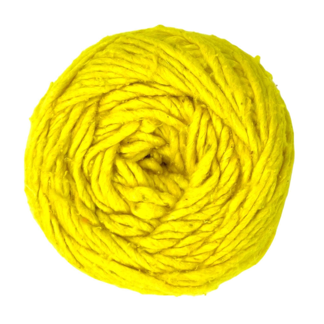 A skein on yellow worsted weight silk yarn called "Illuminating" on a white background.