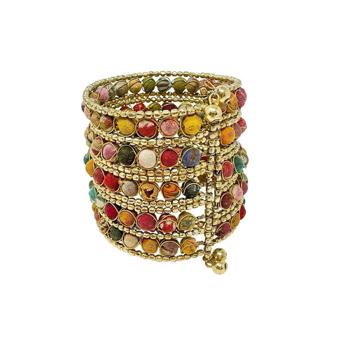 A multicolored, kantha beaded cuff bracelet made with gold beads and wire on a white background.