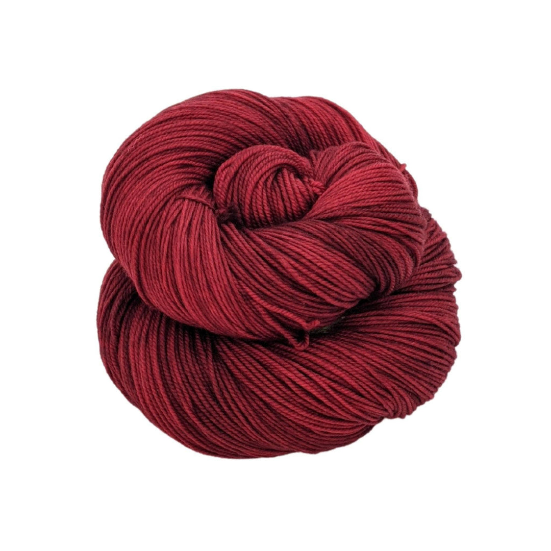 skein of tonal red yarn in front of a white background.