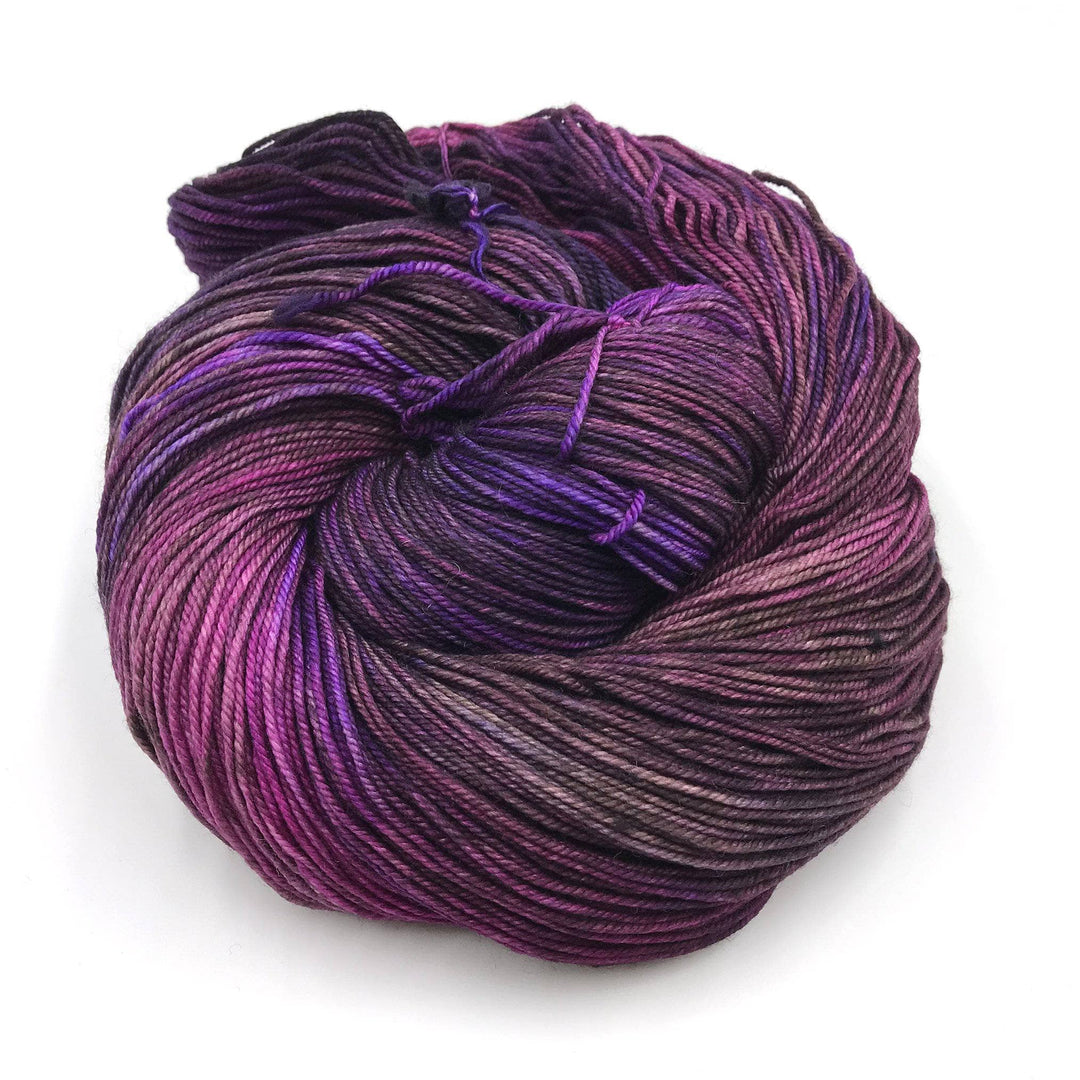 hank of tonal purple yarn in front of a white background.