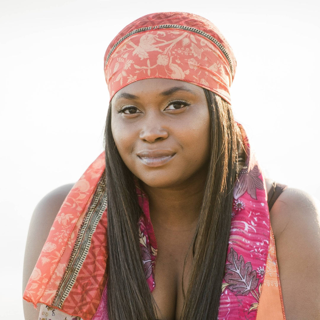 Model is wearing a pink and peach medley scarf as a headband. 