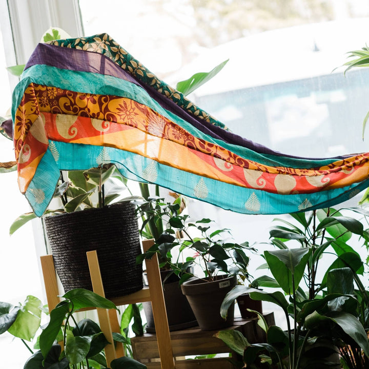 Medley scarf sitting on a window with some plants. 