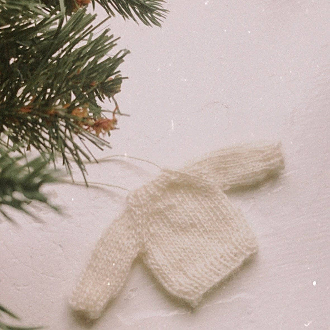 tiny white sweater ornament on a white background