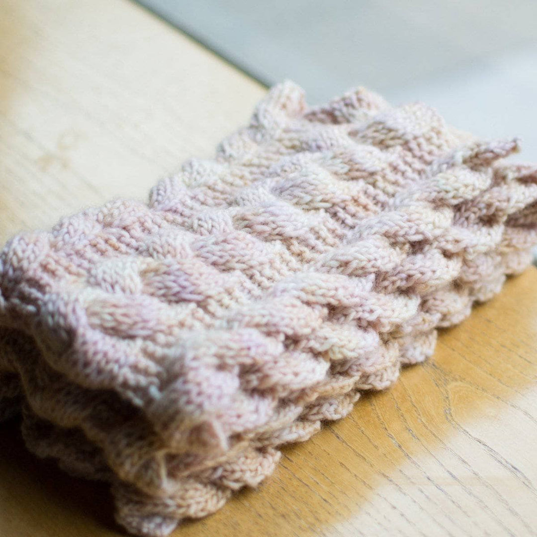 Third Law Cabled Scarf folded on a wooden surface