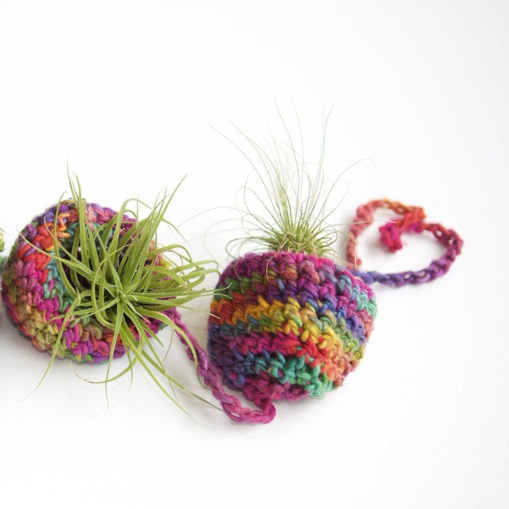 Tiered knit Air Plant Hanger filled with air plants on a white background