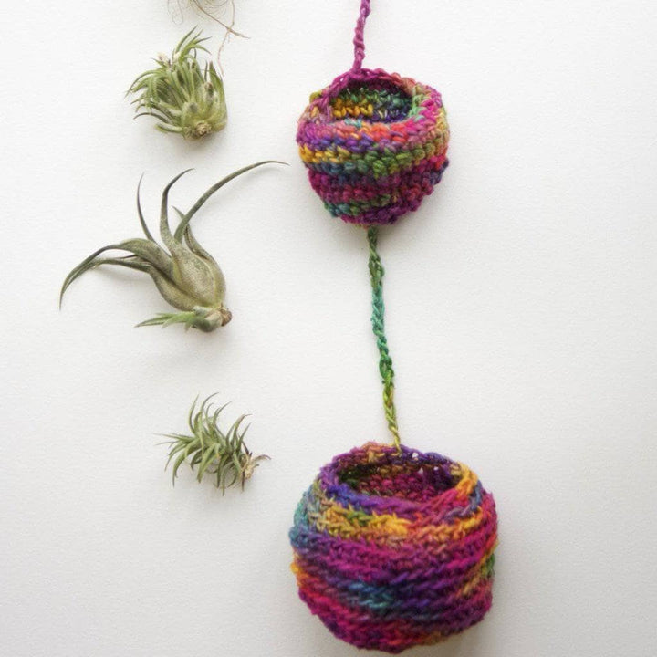 Tiered knit Air Plant Hanger filled with air plants on a white background