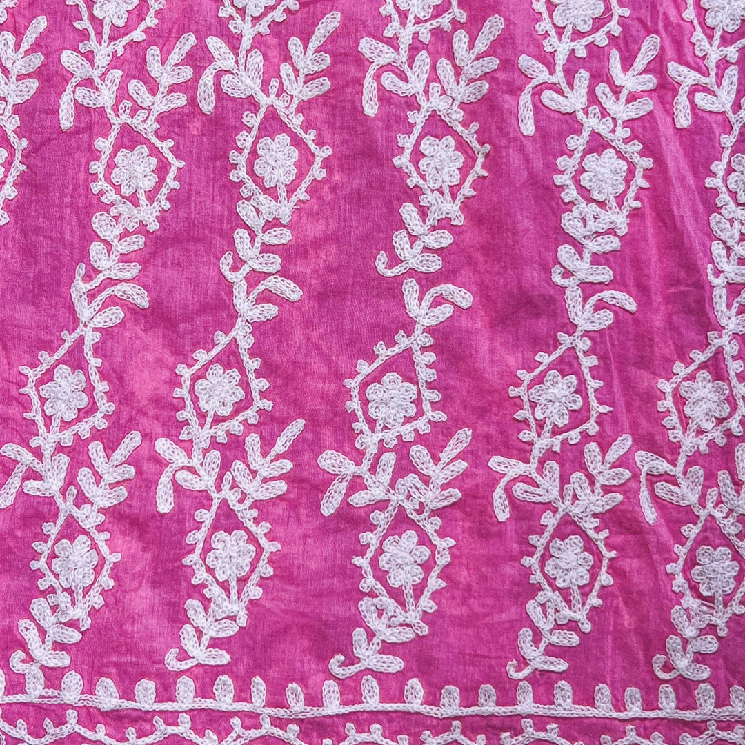 Close-up of a pink/white colorful embroidered kaftan. 