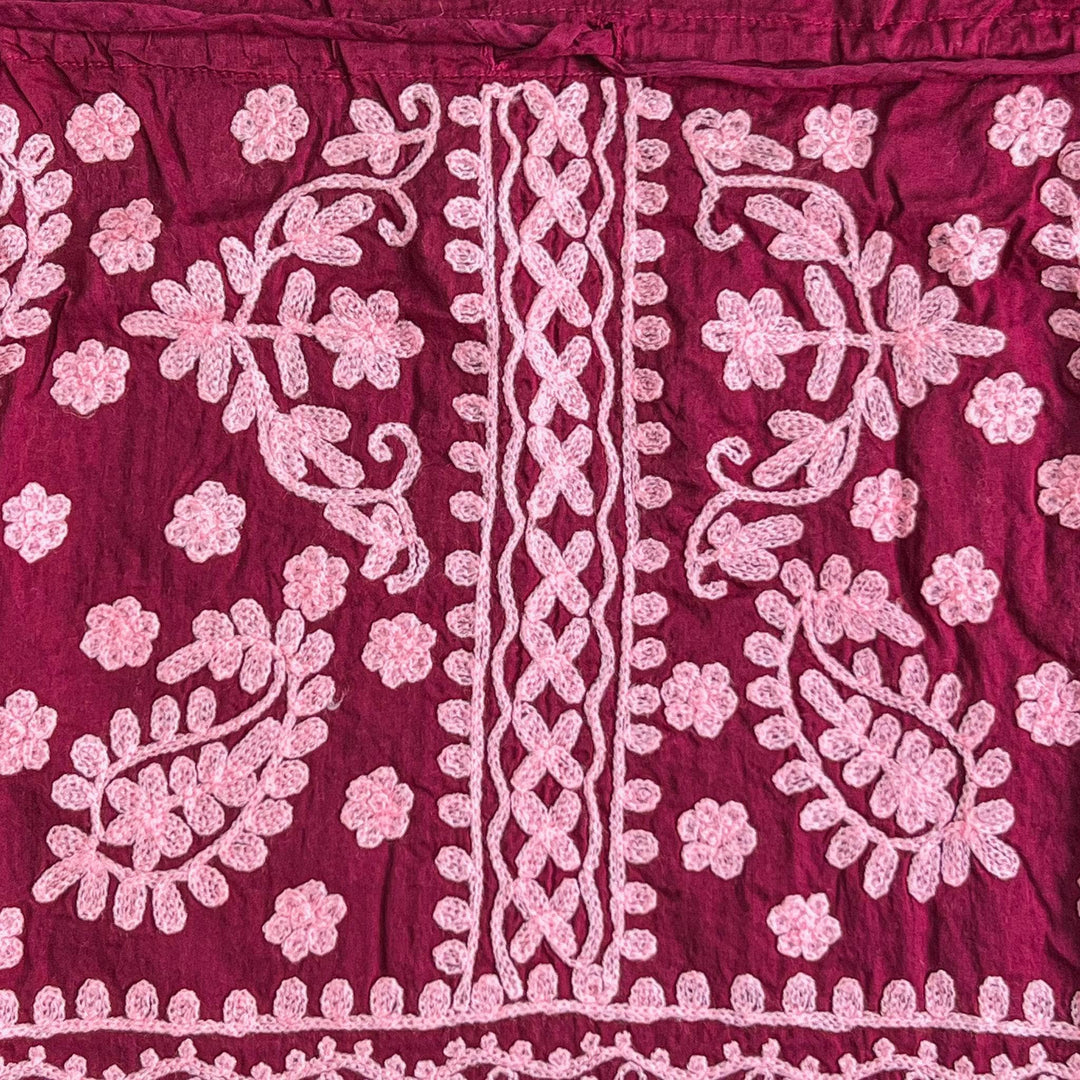Close-up of a red/pink colorful embroidered kaftan.