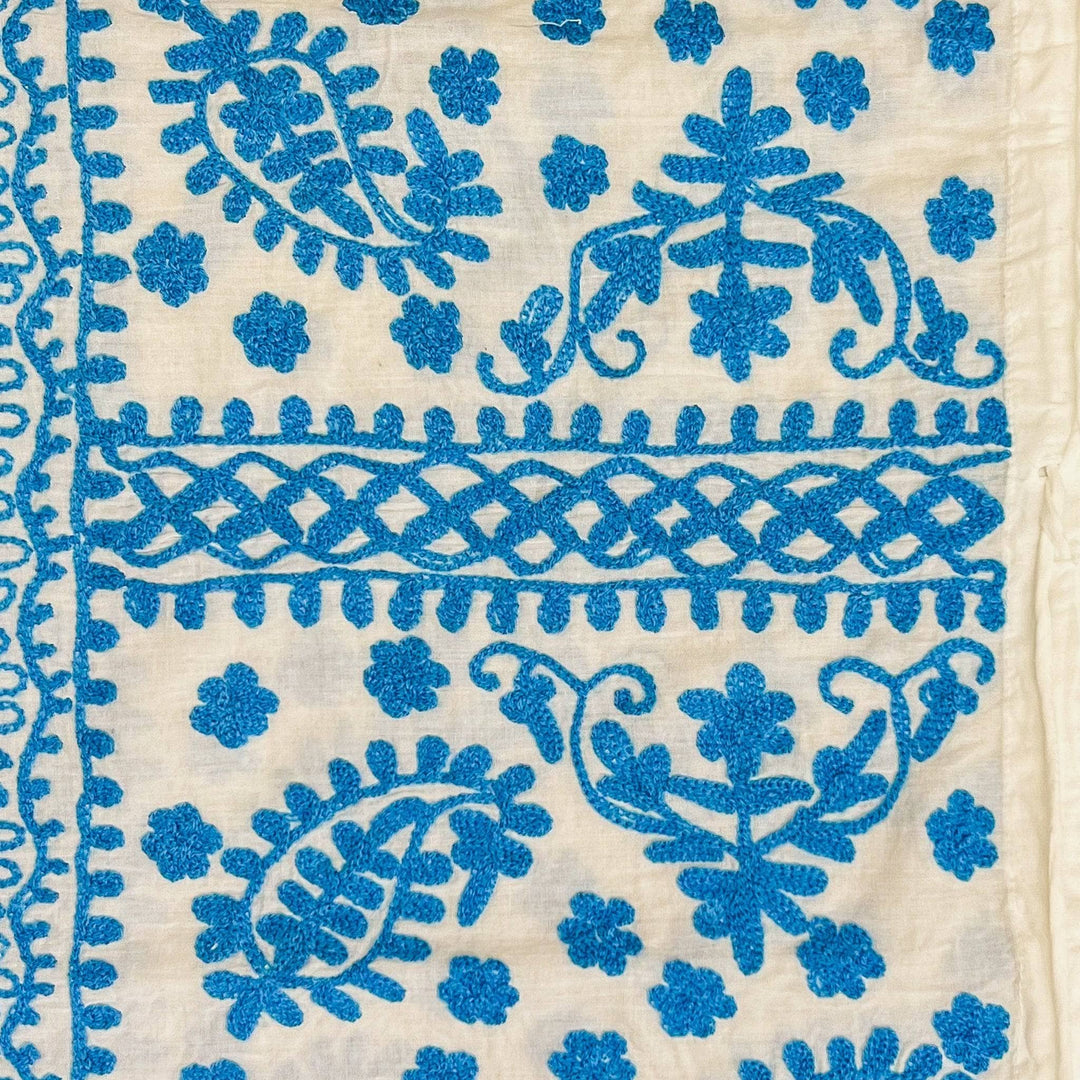 Close-up of a white/light blue classic embroidered kaftan.