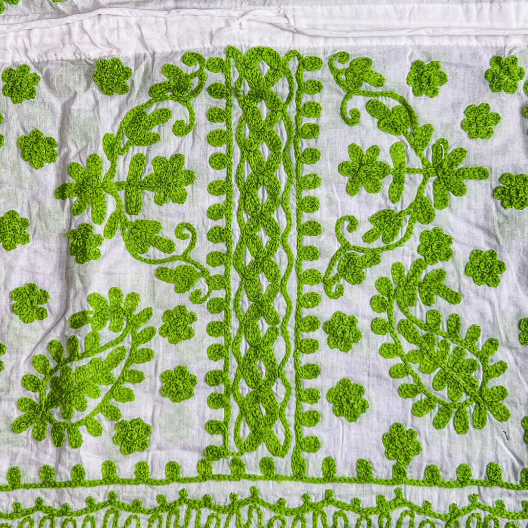 Close-up of a white/ green classic embroidered kaftan.
