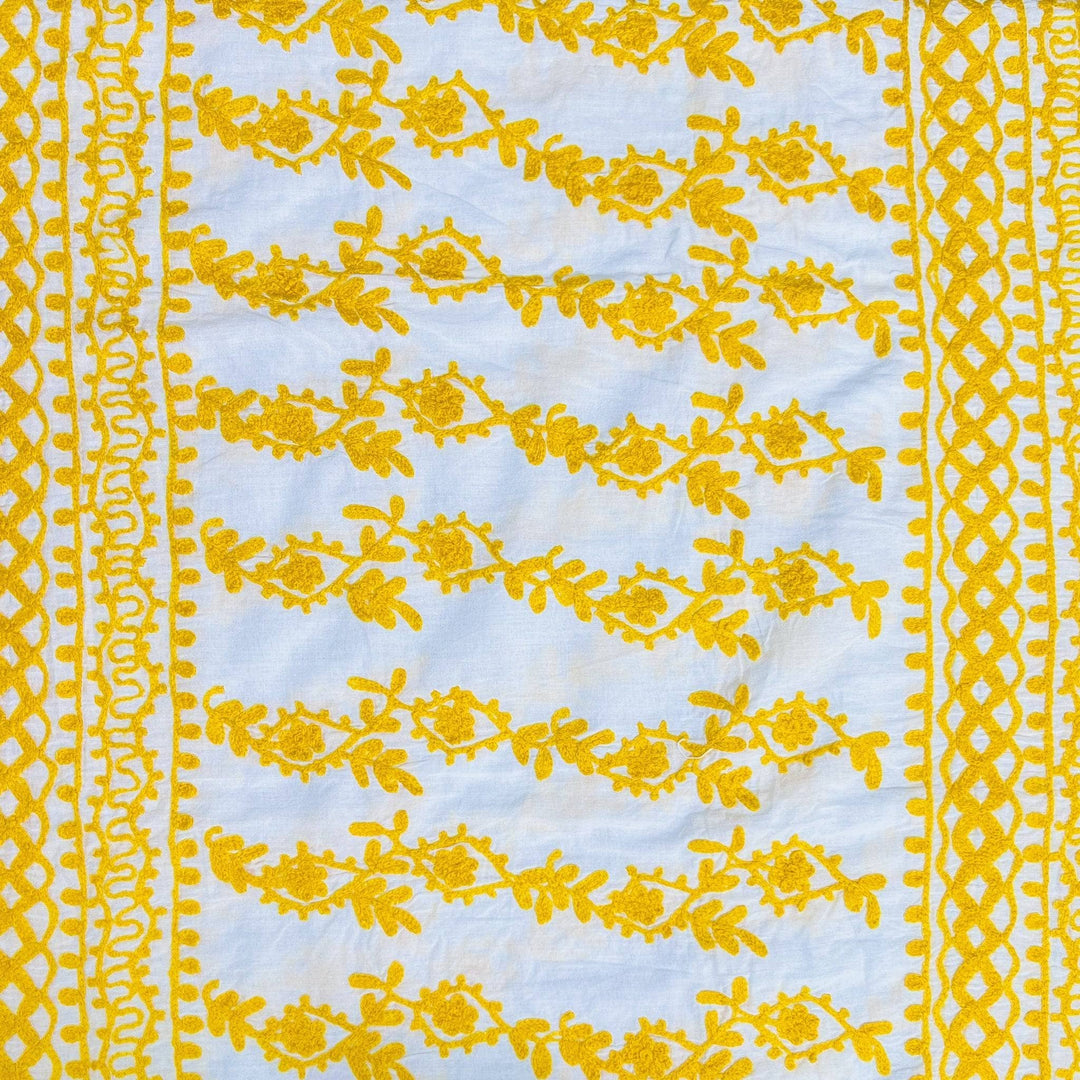 Close-up of a white/ yellow classic embroidered kaftan.