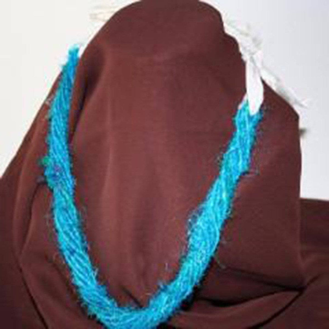 Twist Necklace in blue and white laid over a brown background