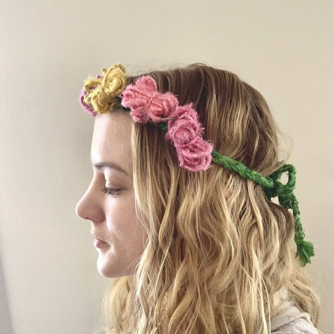 image of designer wearing flower crown made from green sari silk ribbon yarn and 3 different colors of banana fiber yarn.
