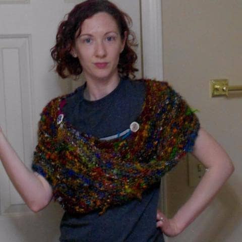 Woman wearing Wild Peacock Wrap in multicolored against a white door