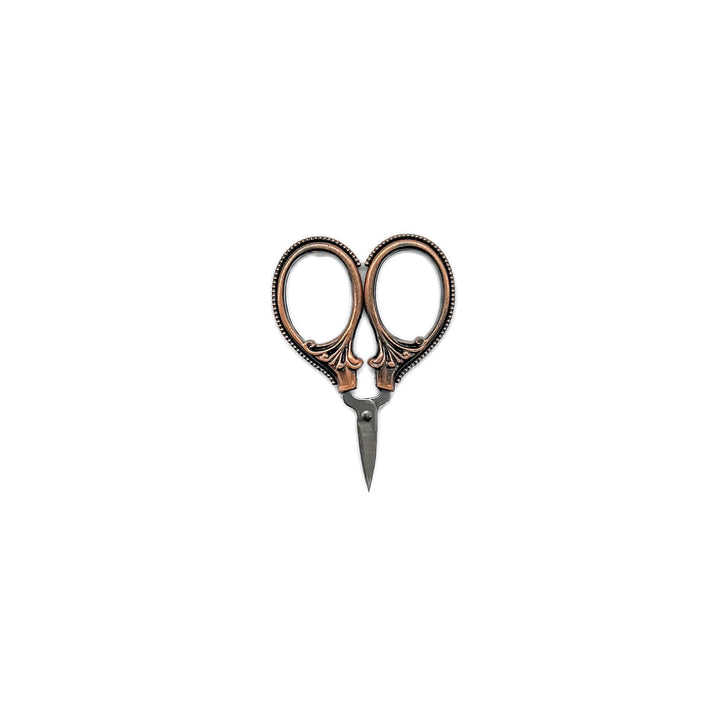 Small craft scissors with a patterned brass handle.