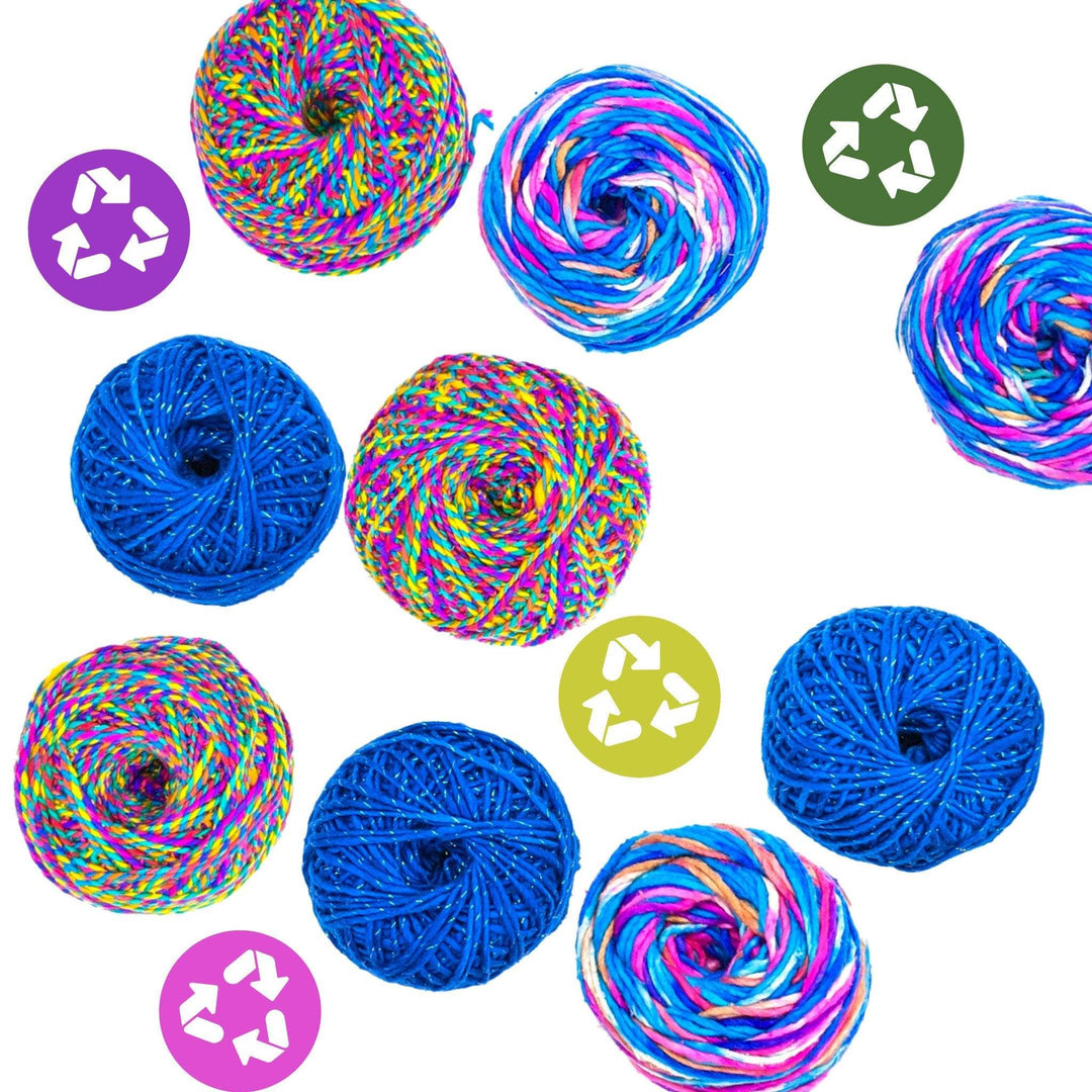 Assorted yarn and colorful recycle signs on a white backdrop. 